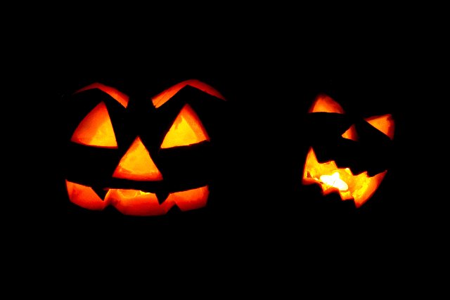 carved pumpkin faces with fire flickering behind them